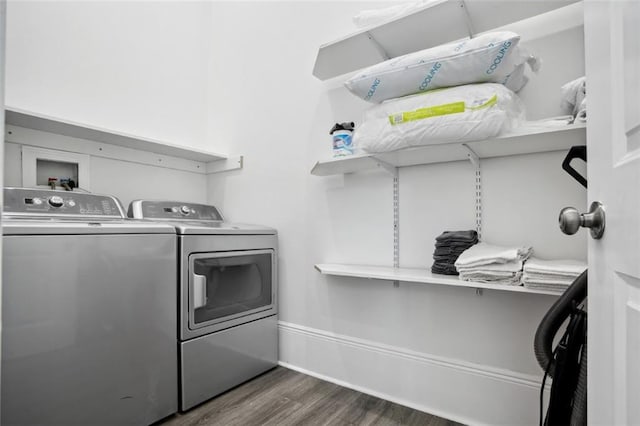 clothes washing area with dark hardwood / wood-style floors and independent washer and dryer