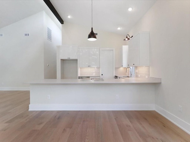 kitchen with light countertops, a sink, visible vents, and white cabinets