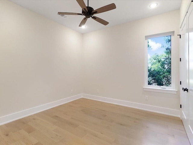 empty room with ceiling fan and light hardwood / wood-style floors