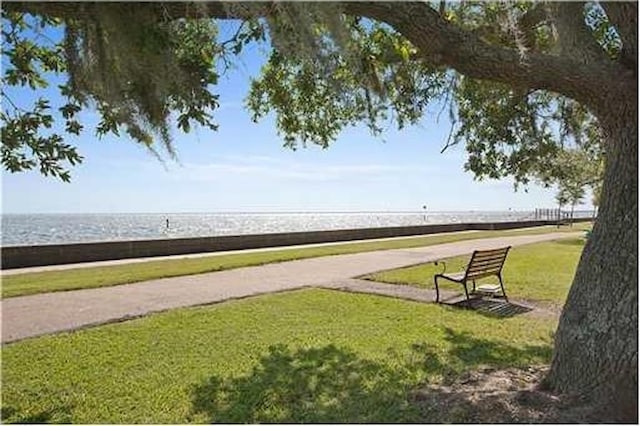 view of property's community featuring a water view and a lawn