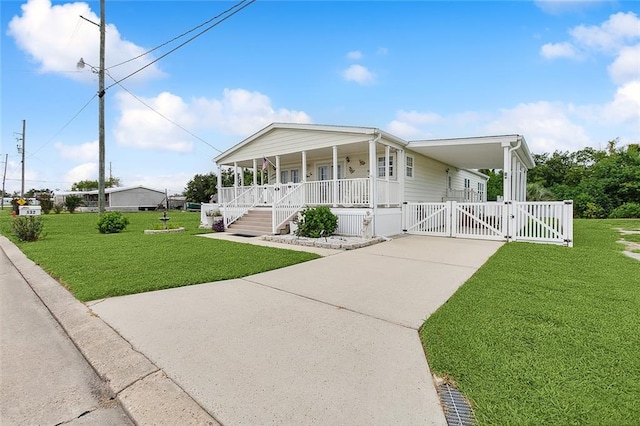 view of front of home with a porch, a front yard, and a carport