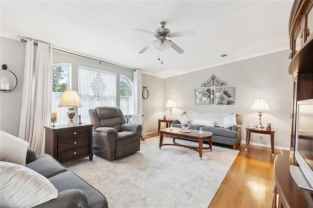 living room featuring light hardwood / wood-style flooring and ceiling fan