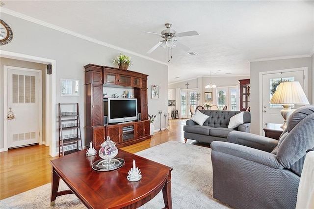 living room featuring light hardwood / wood-style floors, ornamental molding, lofted ceiling, and ceiling fan