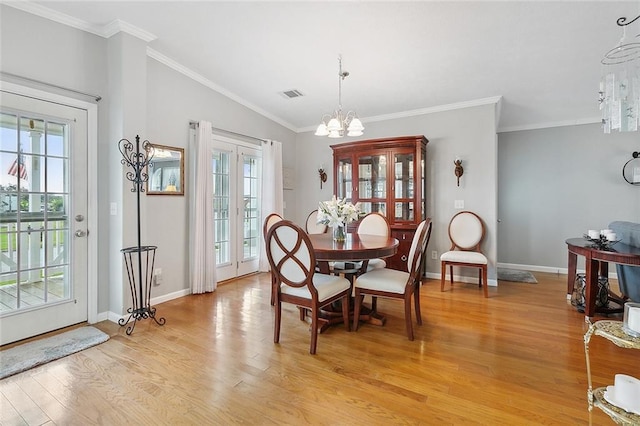 dining area featuring crown molding, a chandelier, lofted ceiling, and light wood-type flooring