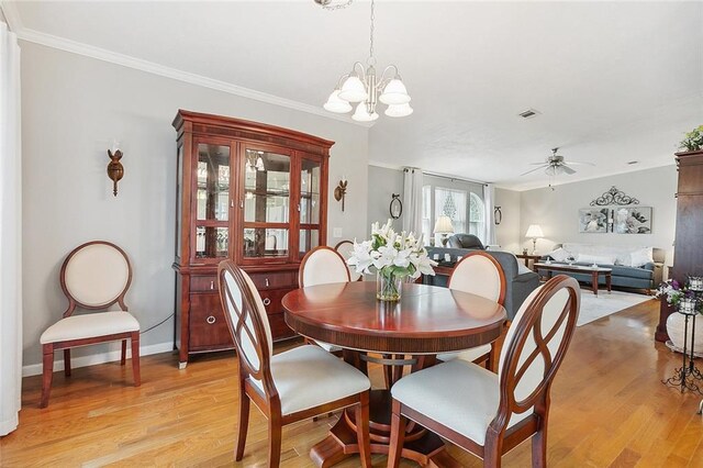 dining space with ornamental molding, light hardwood / wood-style flooring, and ceiling fan with notable chandelier