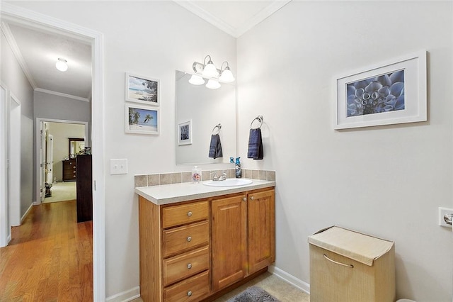 bathroom featuring vanity, ornamental molding, and hardwood / wood-style flooring