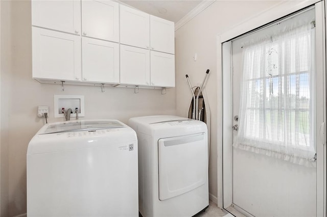 washroom with ornamental molding, independent washer and dryer, and cabinets