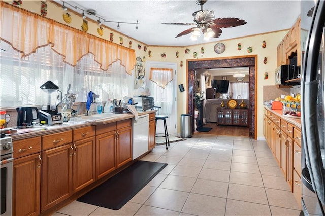 kitchen featuring appliances with stainless steel finishes, light tile patterned floors, and ceiling fan