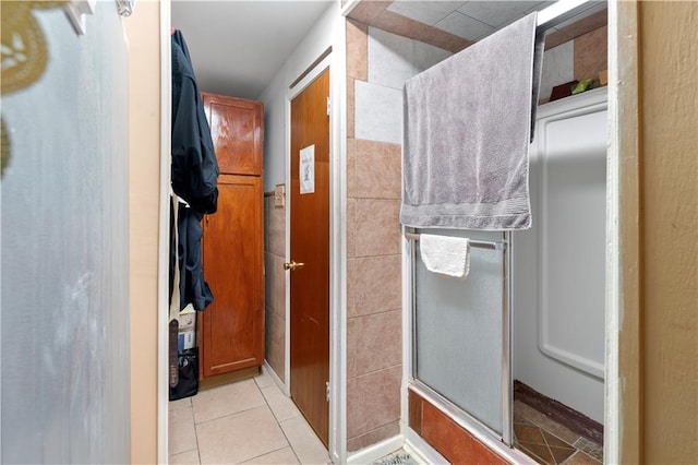 bathroom with a shower with shower door and tile patterned floors