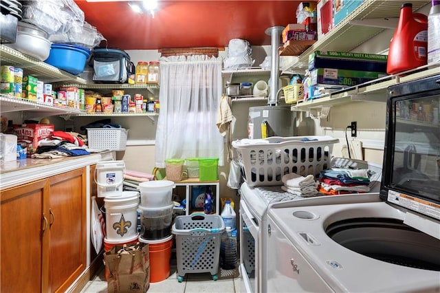 washroom with light tile patterned floors, washing machine and dryer, and gas water heater