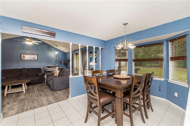 dining room with a textured ceiling, vaulted ceiling, ceiling fan with notable chandelier, and light wood-type flooring