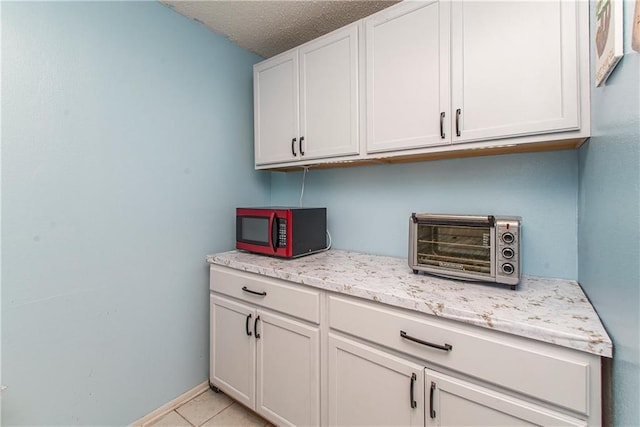 415 Driftwood Cir, Slidell, LA 70458 - kitchen featuring light tile patterned flooring, a textured ceiling, and light stone countertops