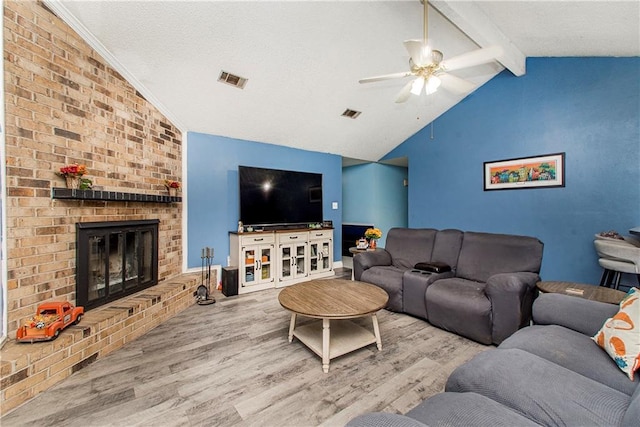 living room featuring hardwood / wood-style flooring, lofted ceiling with beams, a fireplace, and ceiling fan