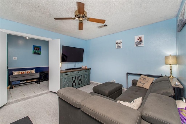 living room with light carpet, a textured ceiling, and ceiling fan