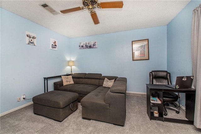 living room with ceiling fan, carpet flooring, and a textured ceiling