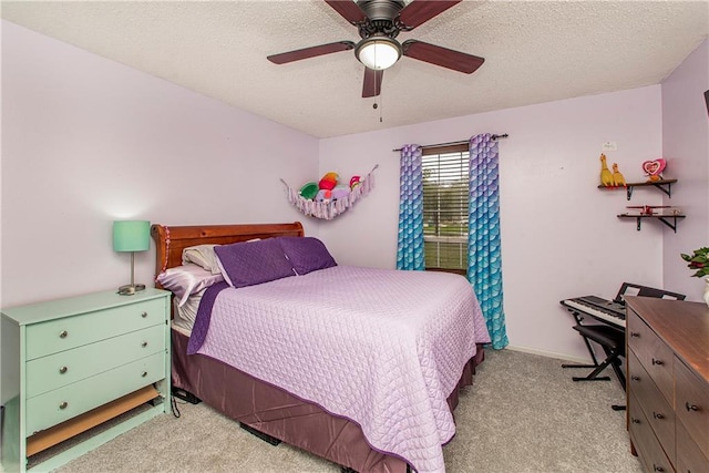 bedroom featuring a textured ceiling, light colored carpet, and ceiling fan