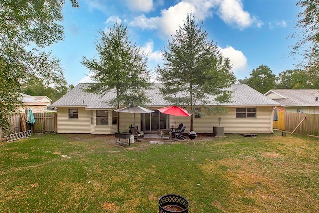 rear view of house featuring a patio area, a fire pit, and a lawn