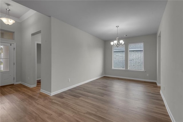 foyer entrance with a wealth of natural light, light hardwood / wood-style flooring, and an inviting chandelier