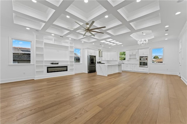 unfurnished living room featuring light hardwood / wood-style floors, crown molding, beam ceiling, and coffered ceiling