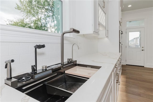 kitchen with white cabinetry, a healthy amount of sunlight, dark wood-type flooring, and decorative backsplash