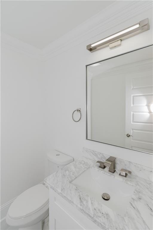 bathroom featuring vanity, toilet, and ornamental molding