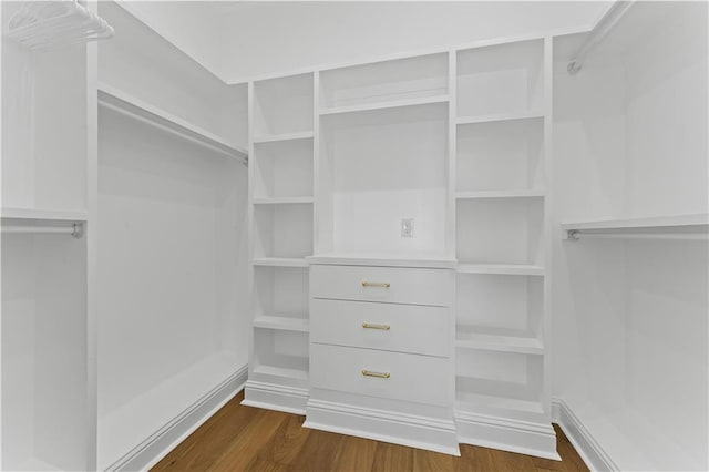 walk in closet with dark wood-type flooring