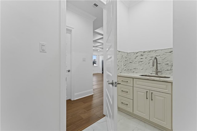 interior space featuring crown molding, sink, and light wood-type flooring