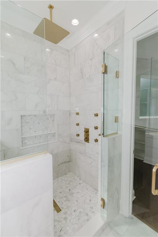 bathroom with crown molding and an enclosed shower