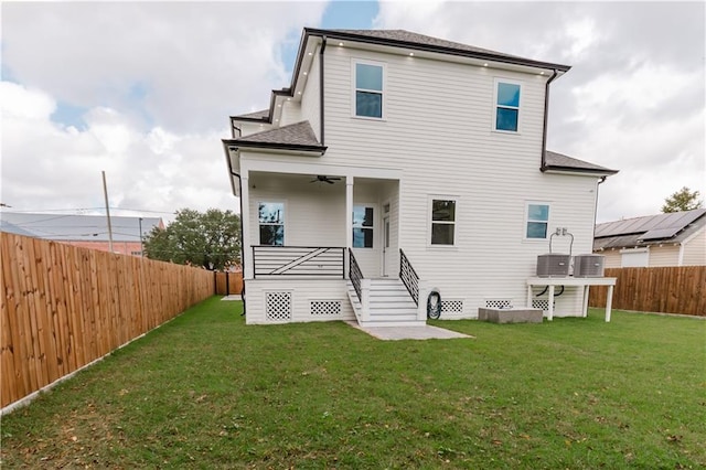 rear view of property featuring a yard, central AC unit, and ceiling fan