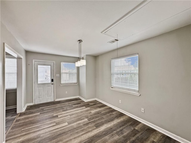 unfurnished dining area featuring dark wood-type flooring and plenty of natural light