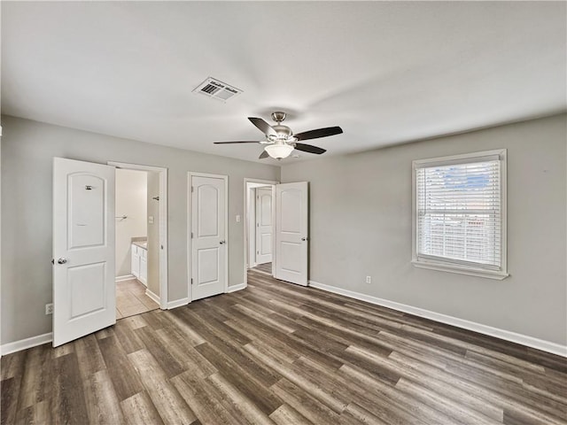 unfurnished bedroom with ceiling fan, dark hardwood / wood-style floors, and ensuite bath