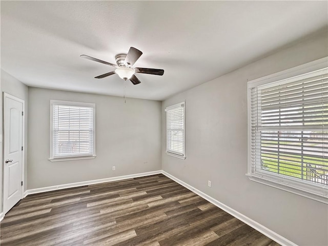 empty room with dark hardwood / wood-style floors and ceiling fan