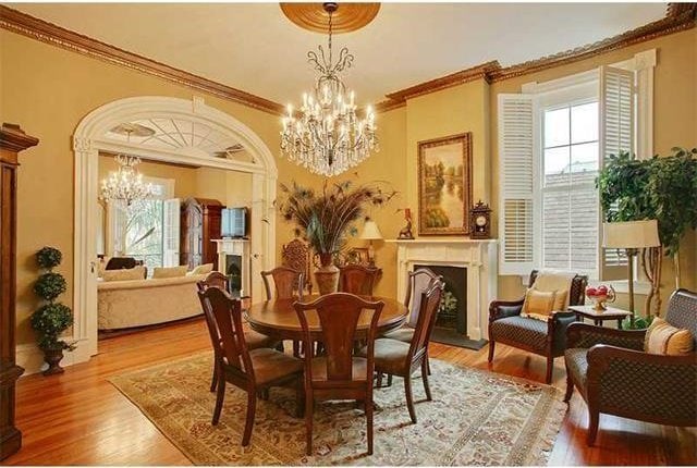 dining space featuring a chandelier, ornamental molding, and light hardwood / wood-style flooring