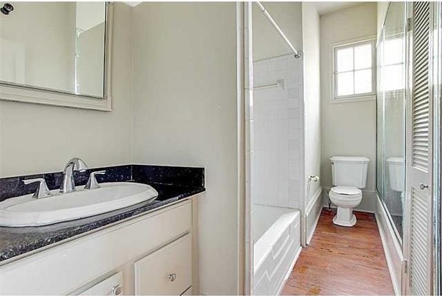 bathroom with toilet, vanity, and hardwood / wood-style flooring