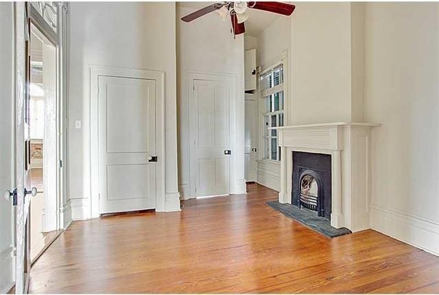 unfurnished living room with ceiling fan and wood-type flooring