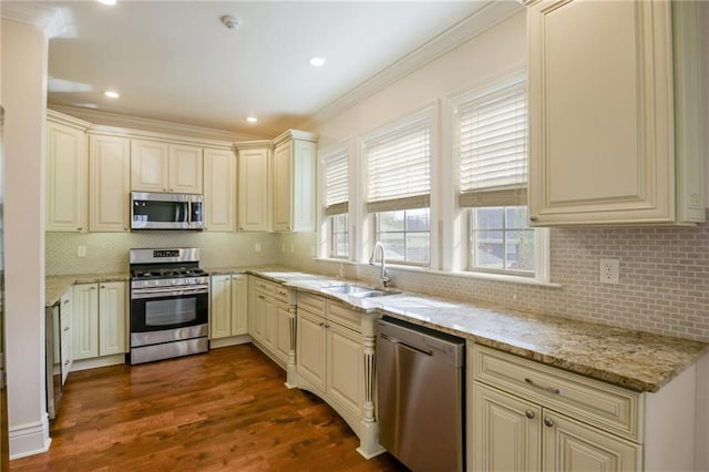 kitchen featuring cream cabinetry, stainless steel appliances, light stone counters, and dark hardwood / wood-style flooring