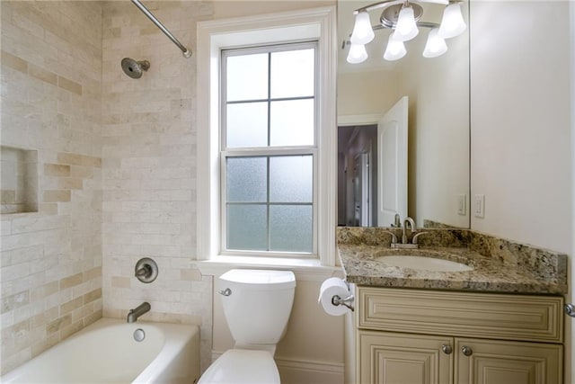 full bathroom featuring toilet, tiled shower / bath, and vanity