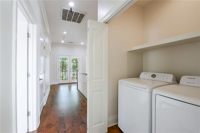 laundry room featuring washer and dryer, french doors, dark wood-type flooring, and crown molding