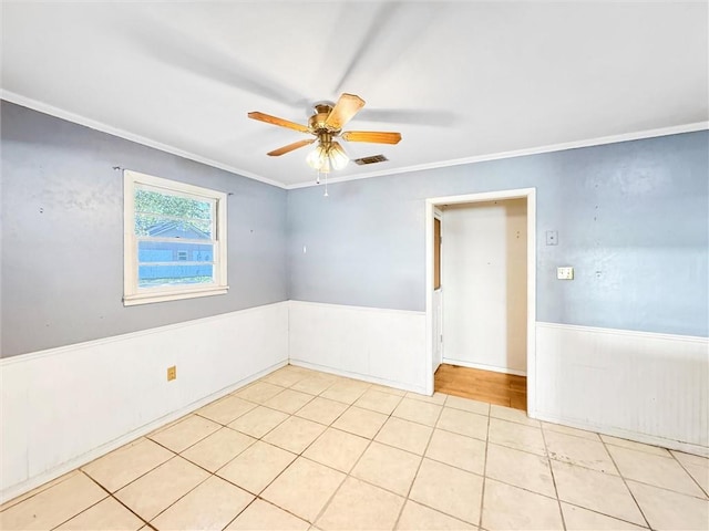 empty room featuring crown molding, ceiling fan, and light tile patterned floors