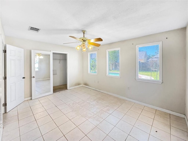 unfurnished bedroom featuring a closet, light tile patterned flooring, and ceiling fan