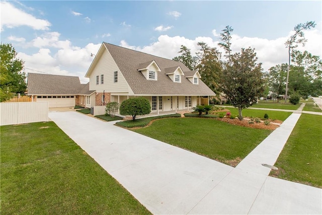 view of front of property with a porch, a front lawn, and a garage