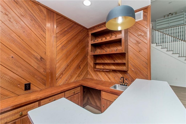 office space featuring wood walls, hardwood / wood-style flooring, and sink