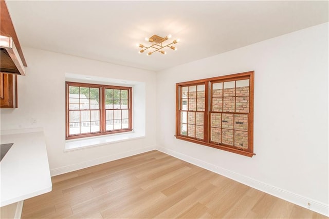 unfurnished dining area featuring light wood-type flooring