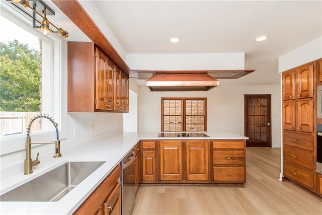 kitchen featuring dishwasher, black electric cooktop, kitchen peninsula, sink, and light hardwood / wood-style floors