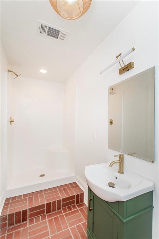 bathroom with vanity and a shower