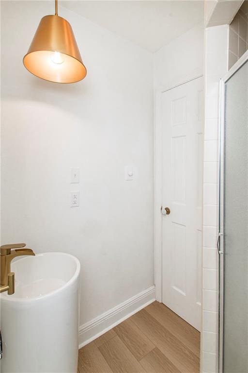 bathroom with wood-type flooring and an enclosed shower