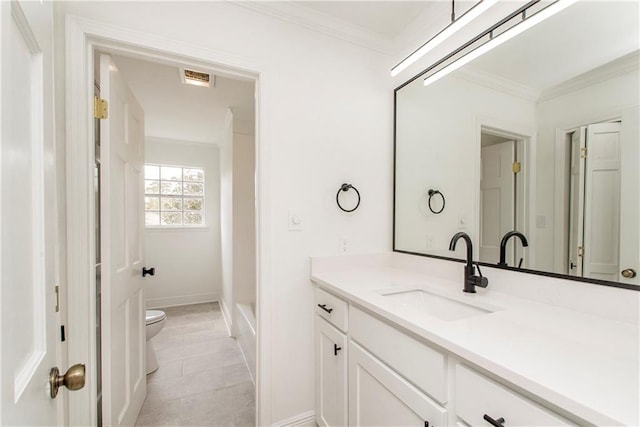 bathroom with vanity, toilet, ornamental molding, and tile patterned flooring