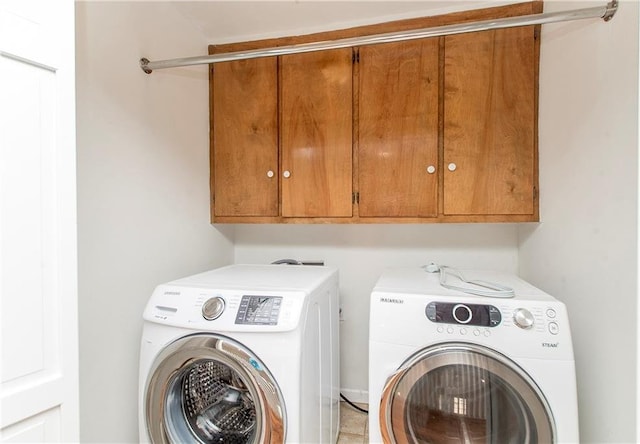 clothes washing area with cabinets and separate washer and dryer