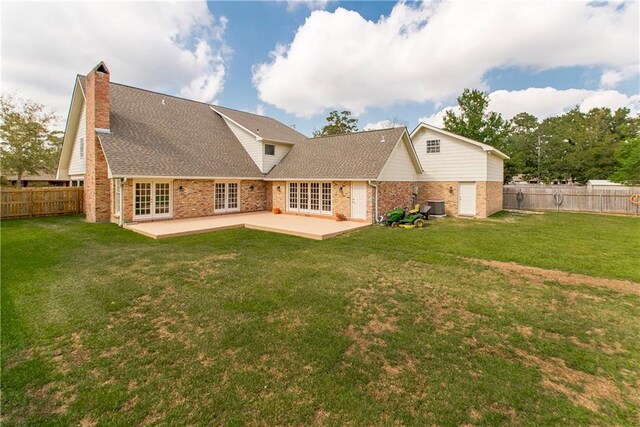 rear view of house featuring a patio, cooling unit, and a yard