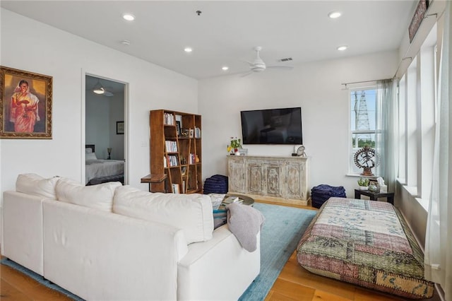 living room with ceiling fan and light hardwood / wood-style flooring